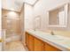 Well-lit bathroom with double sinks, framed mirrors, a shower-tub combo, and neutral tile flooring at 8414 Frescada Ct, Orlando, FL 32836