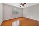 A bedroom featuring a large window, hardwood floors, and a ceiling fan at 8414 Frescada Ct, Orlando, FL 32836