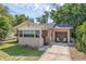 Inviting home exterior showcases a small front porch, attached garage, and a lush green lawn at 849 Driver Ave, Winter Park, FL 32789