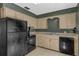 Traditional kitchen featuring black appliances, neutral countertops, and ample cabinet space at 849 Driver Ave, Winter Park, FL 32789