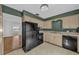 Traditional kitchen featuring black appliances, neutral countertops, and ample cabinet space at 849 Driver Ave, Winter Park, FL 32789