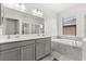 Bathroom featuring a double vanity, soaking tub, and a separate glass enclosed shower at 8990 Azalea Sands Ln # 8990, Davenport, FL 33896