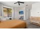 Bright bedroom featuring a ceiling fan, balcony access, TV, and a cozy crib at 8990 Azalea Sands Ln # 8990, Davenport, FL 33896