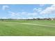 Scenic green field view dotted with trees and houses under a blue sky with fluffy white clouds at 8990 Azalea Sands Ln # 8990, Davenport, FL 33896