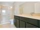 Bathroom featuring a dual sink vanity with dark cabinetry and a glass-enclosed shower at 9069 Shepton St, Orlando, FL 32825