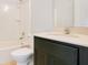 Bathroom featuring a toilet, tub and shower combination, and a single sink vanity with black cabinetry at 9069 Shepton St, Orlando, FL 32825