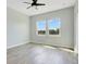 Bright bedroom featuring wood-look floors, neutral walls, ceiling fan, and dual windows overlooking the property at 9069 Shepton St, Orlando, FL 32825