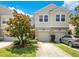 Two-story townhome with a well-maintained lawn, lush landscaping, and private garage and driveway at 9069 Shepton St, Orlando, FL 32825