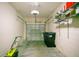 A residential garage containing storage shelves, rolling garbage bins, and a lawn mower at 9069 Shepton St, Orlando, FL 32825