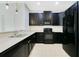 Modern kitchen featuring black appliances, dark cabinetry, and sleek countertops at 9069 Shepton St, Orlando, FL 32825