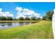 View of the pond surrounded by lush greenery and a white picket fence at 9069 Shepton St, Orlando, FL 32825