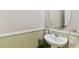 Elegant half-bathroom featuring a pedestal sink, oval mirror, and decorative details at 976 Eagle Bay St, Winter Springs, FL 32708