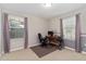 This carpeted bedroom has neutral walls, two large windows and is set up as an office at 976 Eagle Bay St, Winter Springs, FL 32708