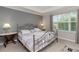 Serene main bedroom with tray ceilings, large window, and silver metal bed frame, illuminated by bedside lamps at 976 Eagle Bay St, Winter Springs, FL 32708