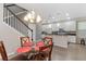 Charming dining area featuring a glass table, chandelier, and staircase to the upper level of the home at 976 Eagle Bay St, Winter Springs, FL 32708