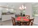 Open dining area with glass table, chandelier, and view of the kitchen and living room in a light-filled space at 976 Eagle Bay St, Winter Springs, FL 32708