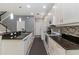 Modern kitchen with white cabinets, granite countertops, mosaic backsplash, and stainless steel appliances at 976 Eagle Bay St, Winter Springs, FL 32708