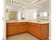 Bathroom with a large mirror over the sinks and cabinetry plus an adjacent glass shower at 9836 Old Patina Way, Orlando, FL 32832