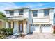 Two-story home showcasing a brick driveway, a well-maintained lawn, and a two-car garage at 9836 Old Patina Way, Orlando, FL 32832