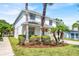 Two-story home featuring brick driveway, palm trees, well-kept lawn, and a convenient two-car garage at 9836 Old Patina Way, Orlando, FL 32832