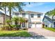 Two-story home featuring brick driveway, palm trees, well-kept lawn, and a convenient two-car garage at 9836 Old Patina Way, Orlando, FL 32832