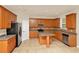 Kitchen featuring wood cabinets, stainless appliances, and an island for food preparation at 9836 Old Patina Way, Orlando, FL 32832