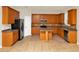 Kitchen featuring wood cabinets, stainless appliances, and an island for food preparation at 9836 Old Patina Way, Orlando, FL 32832