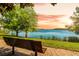 Beautiful lake view featuring a bench for scenic relaxation under a picturesque sunset at 9836 Old Patina Way, Orlando, FL 32832