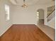 Living room featuring hardwood floors, neutral walls, and an elegant light fixture at 9836 Old Patina Way, Orlando, FL 32832