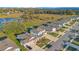 Aerial view of modern homes with well-manicured lawns and a backdrop of lush greenery and serene water at 10249 Spring Lake Dr, Clermont, FL 34711