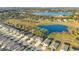 The aerial view captures houses beside a golf course and pond, blending natural beauty with residential comfort at 10249 Spring Lake Dr, Clermont, FL 34711