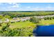 A picturesque aerial shot of a residential neighborhood, showcasing lush greenery and a serene pond at 10249 Spring Lake Dr, Clermont, FL 34711