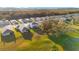 Expansive aerial view showcases residences nestled on meticulously kept lawns and a tranquil pond at 10249 Spring Lake Dr, Clermont, FL 34711