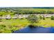 An aerial view of a neighborhood featuring well-maintained lawns and a large pond at 10249 Spring Lake Dr, Clermont, FL 34711