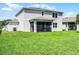The backyard of the home features a covered lanai overlooking the manicured lawn at 10249 Spring Lake Dr, Clermont, FL 34711