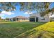 Backyard view of large home with lots of lush green grass at 10249 Spring Lake Dr, Clermont, FL 34711