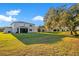 Wide shot of the backyard showing off the green grass and screened-in porch at 10249 Spring Lake Dr, Clermont, FL 34711