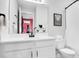 Modern bathroom featuring a white vanity, large mirror, and a view into a bright red room at 10249 Spring Lake Dr, Clermont, FL 34711