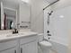 Well-lit bathroom featuring a single sink vanity, toilet, and a tub and shower with black fixtures at 10249 Spring Lake Dr, Clermont, FL 34711