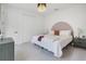 Cozy bedroom featuring a soft white quilt, a unique half-circle headboard design, and matching bedside tables at 10249 Spring Lake Dr, Clermont, FL 34711