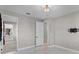 View of a bedroom showing neutral tile, wall-mounted tv bracket, and doorways to bath and hall at 10249 Spring Lake Dr, Clermont, FL 34711