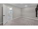 View of a bedroom leading to a bright bathroom, featuring neutral carpet and a closet shelf at 10249 Spring Lake Dr, Clermont, FL 34711