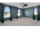 Airy bedroom with ceiling fan, multiple light-filled windows and plush, neutral carpeting at 10249 Spring Lake Dr, Clermont, FL 34711