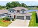 Two-story home with a three car garage, landscaped front yard, gray trim and water view at 10249 Spring Lake Dr, Clermont, FL 34711