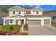 Charming two-story home with a well-manicured lawn, two-car garage, and beautiful landscaping at 10249 Spring Lake Dr, Clermont, FL 34711