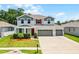 Two-story home with a three car garage, landscaped front yard, gray trim, and red shutters at 10249 Spring Lake Dr, Clermont, FL 34711