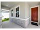 Stylish front porch with stone accents and a red front door for an inviting entry at 10249 Spring Lake Dr, Clermont, FL 34711