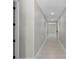 Bright hallway with white doors and trim, featuring sleek, modern flooring and recessed lighting at 10249 Spring Lake Dr, Clermont, FL 34711