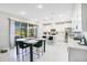A modern kitchen with a marble table, black chairs, stainless steel appliances and white cabinets at 10249 Spring Lake Dr, Clermont, FL 34711