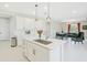 Open-concept kitchen with white cabinets, an island with sink, and an adjacent dining and living area at 10249 Spring Lake Dr, Clermont, FL 34711